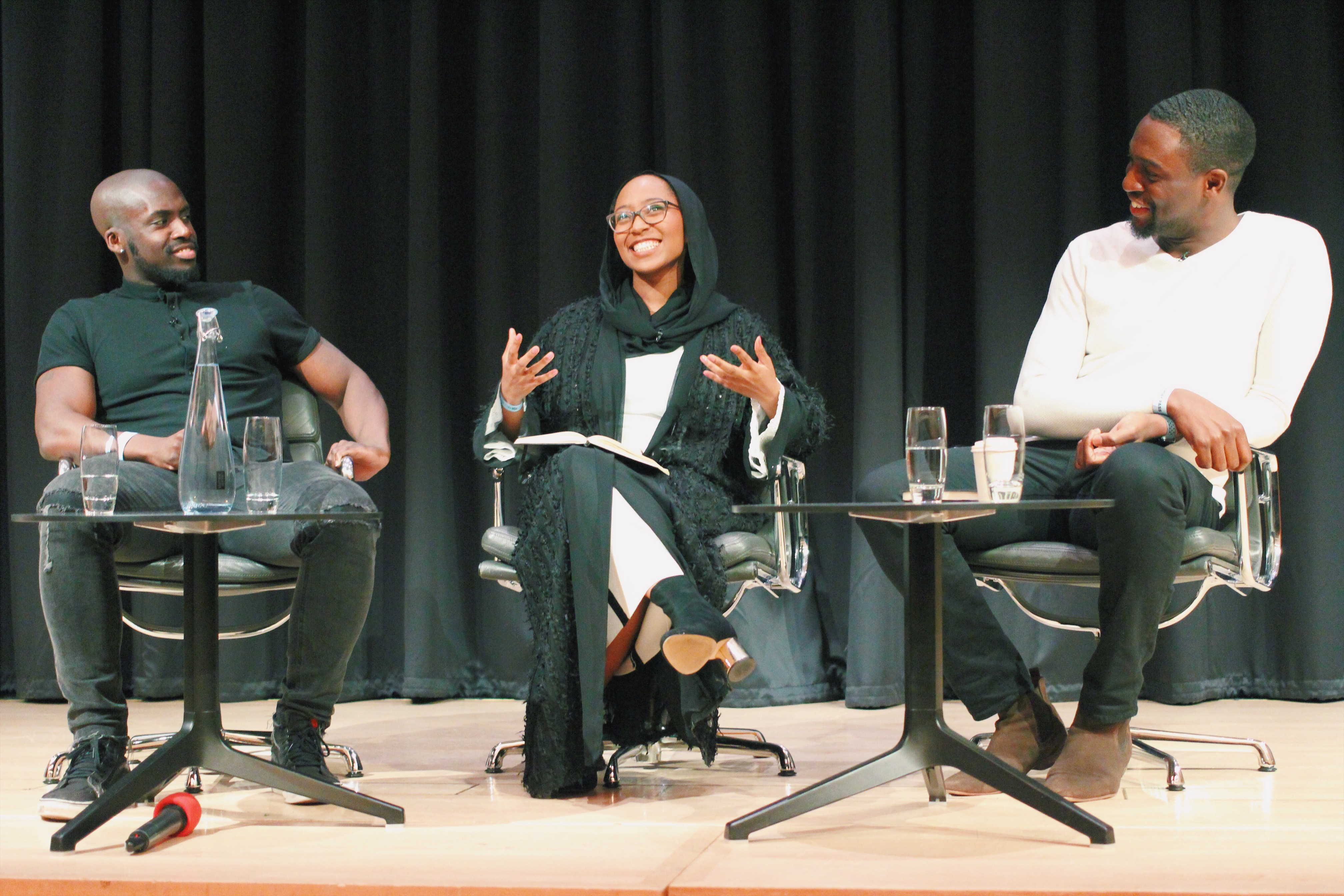 3 people sitting down on a stage speaking