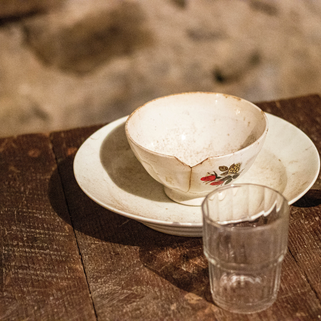 broken cup and empty glass on table
