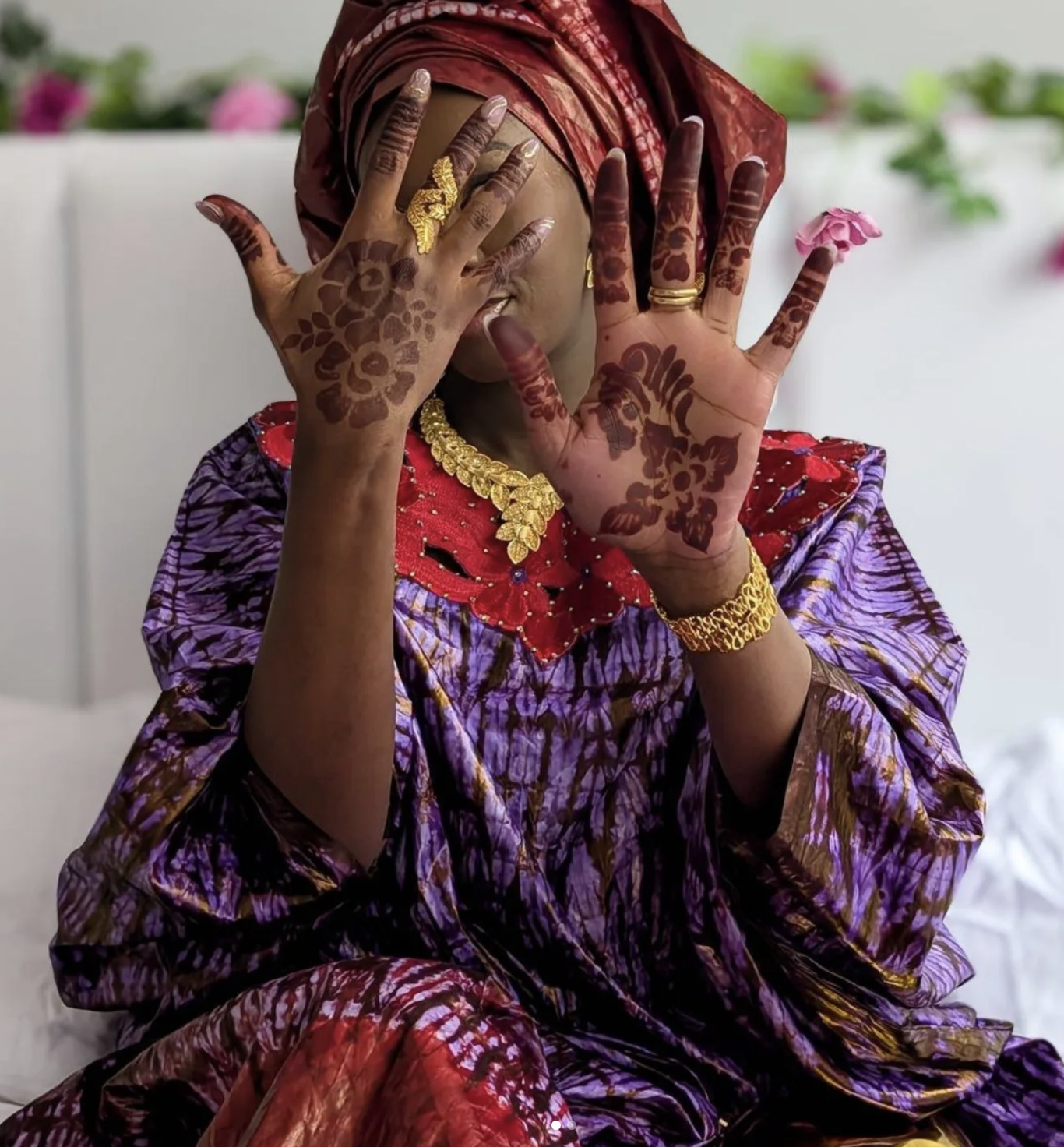 A Black Muslim woman showing two hands decorated with African Henna design