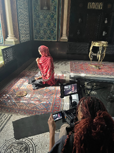 behind the scenes of a girl making dua wearing a red dupatta on the set of film Henna by Basma Khalifa