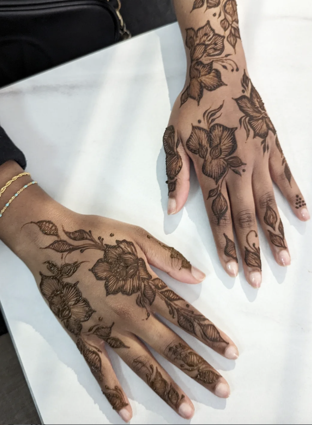 back of two hands showing khaleeji henna designs