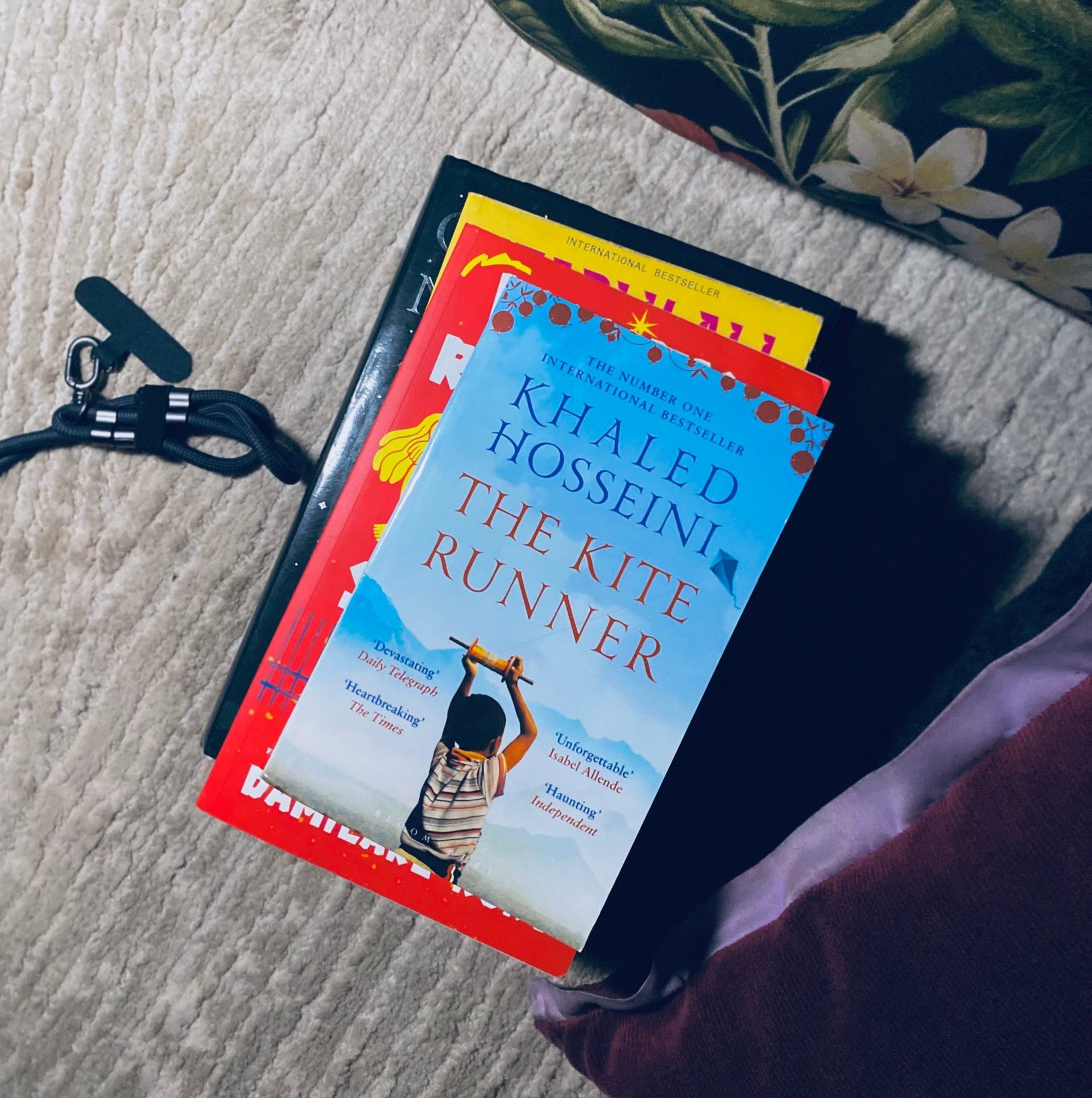 a stack of books showing Khaled Hosseini's Kite Runner on top. Why are Muslim authors writing caricatures of Muslim women